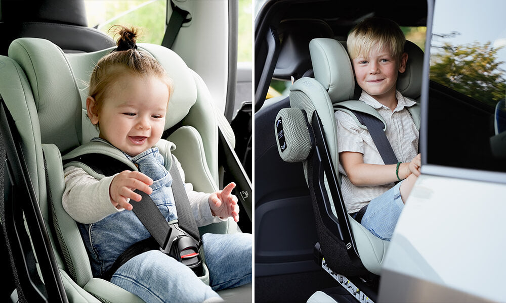 Duas crianças de idades diferentes (bebé e rapaz mais velho) felizes e seguras na cadeira auto Axkid ONE 3+ na cor verde-água (sage green).