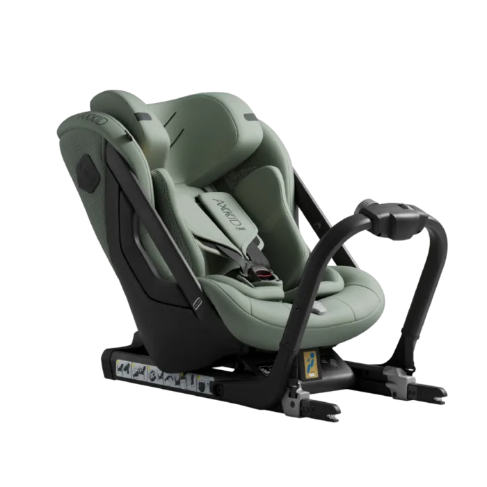Cadeira auto Axkid ONE 3 de cor verde-azeitona, vista de lado, com base ISOFIX e arnês de segurança visíveis.