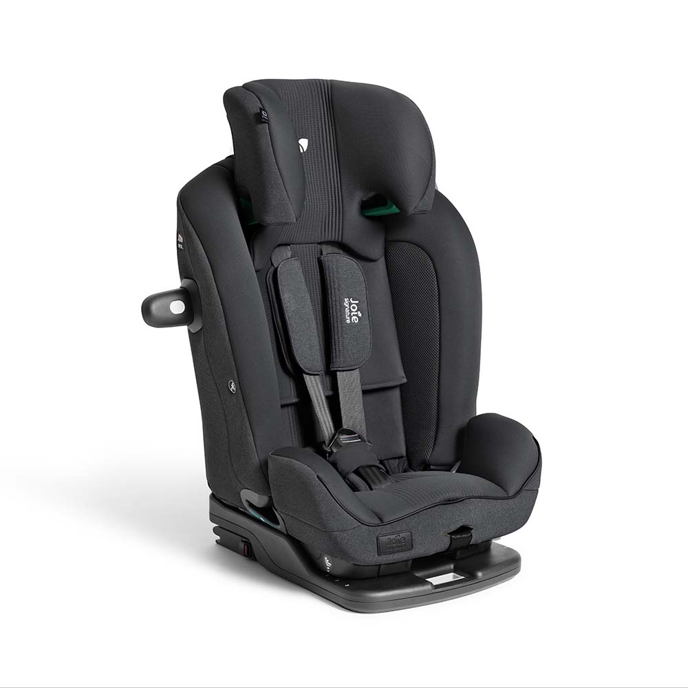 Cadeira auto Joie i-Plenti Signature preta em ângulo, destacando os painéis laterais de proteção e o arnês de 5 pontos com logótipo Joie.