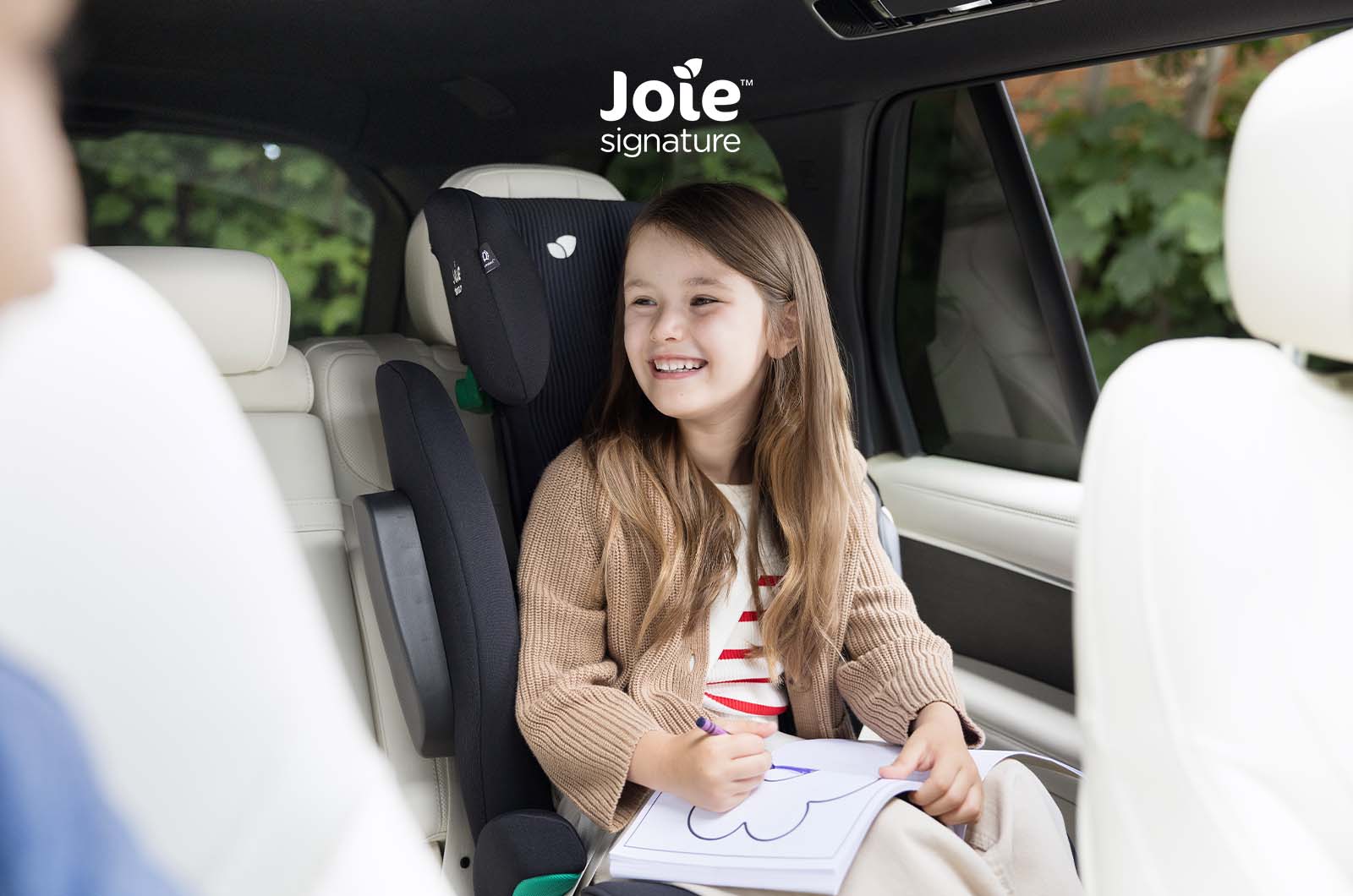 Vista lateral da cadeira auto Joie i-Traver Signature, destacando os painéis laterais Guard Surround Safety™ para proteção contra impactos.