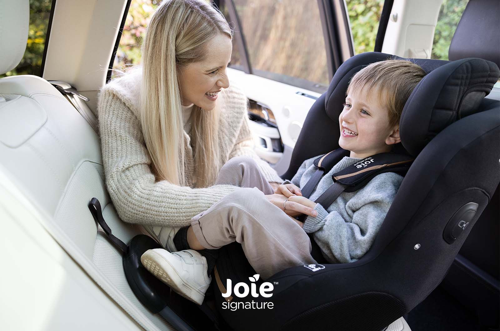 Criança mais velha (cerca de 5-6 anos) sentada confortavelmente na cadeira Joie i-Prodigi PRO em posição contra a marcha, evidenciando o espaço para as pernas.