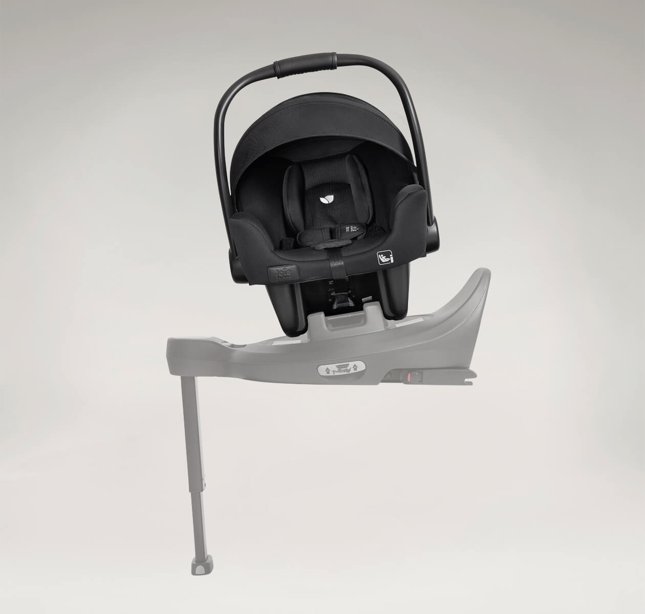 Cadeira auto ovo Joie i-Starter encaixada numa base de carro cinzenta (i-Base Encore), com o pé de apoio estendido no chão.