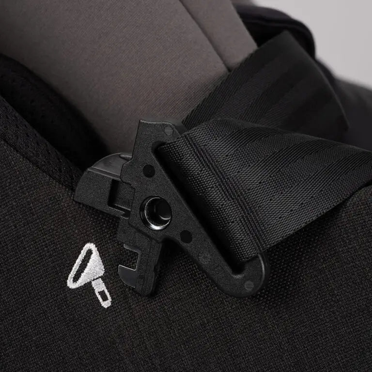 Detalhe do fecho de segurança do arnês de 5 pontos da cadeira auto Nuna Pruu Aire, com bordado de um cadeado.