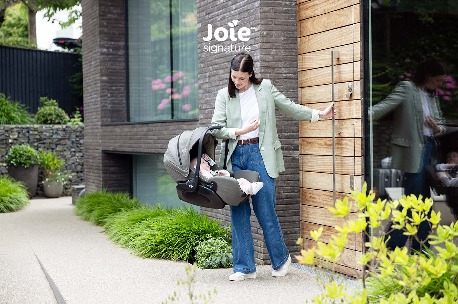 Detalhe da capota retrátil da cadeira auto ovo Joie i-Level Pro Signature, exibindo o fecho para o painel de ventilação.