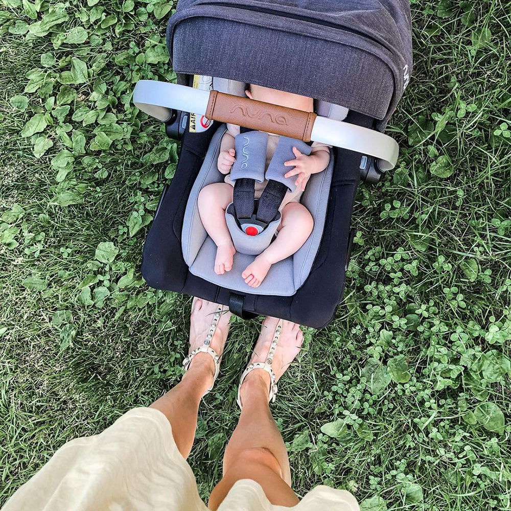 Cadeira auto ovo Nuna Pipa Next com a capota estendida (Dream drape™) a cobrir totalmente a criança para proteção solar e escuridão.