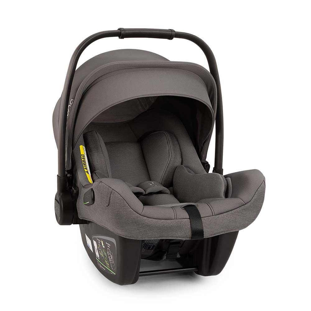 A cadeira auto ovo Nuna Pipa Next com a capota estendida (Dream Drape) fechada magneticamente, proporcionando sombra total para o bebé.