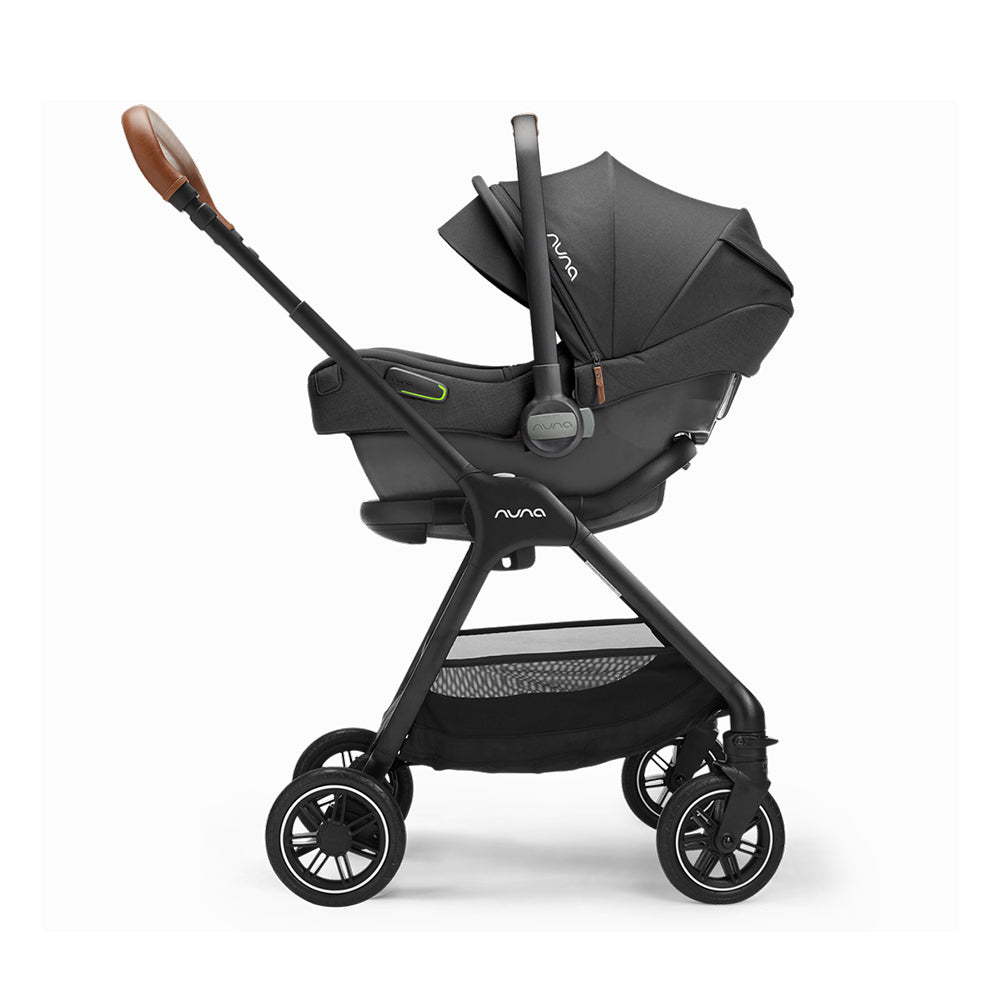 Cadeira auto ovo Nuna Pipa Next na cor preto, vista de lado, instalada no carro com a BASE™ next, mostrando a posição contra marcha e o apoio de cabeça ajustável.