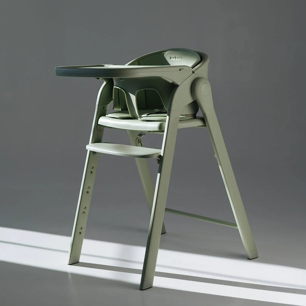 Cadeira de refeição evolutiva Love & Carry Flex na cor verde-menta, vista de frente, mostrando a configuração de cadeira alta dobrável.