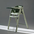 Cadeira de refeição evolutiva Love & Carry Flex na cor verde-menta, vista de frente, mostrando a configuração de cadeira alta dobrável.