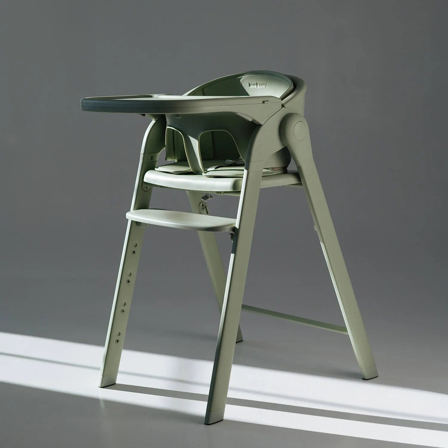 Cadeira de refeição evolutiva Love & Carry Flex na cor verde-menta, vista de frente, mostrando a configuração de cadeira alta dobrável.