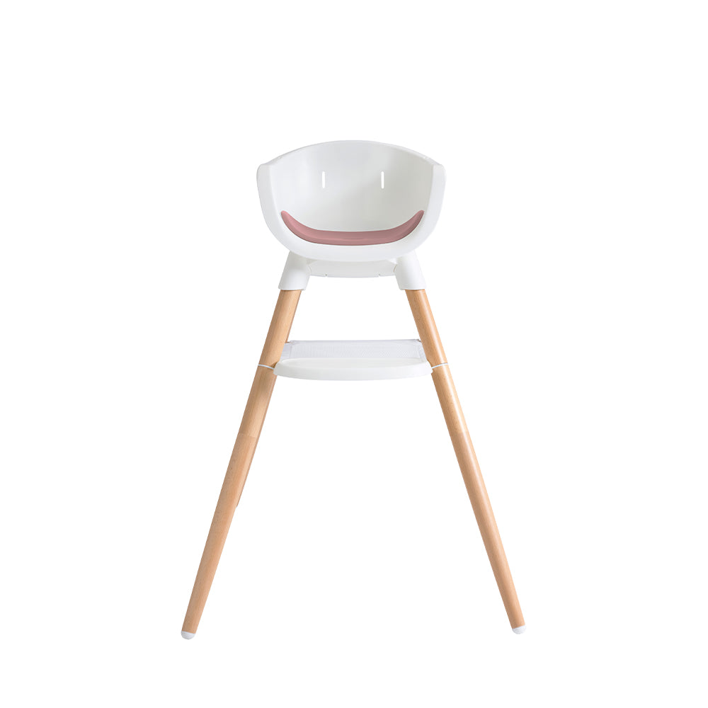 Cadeira de refeição Joie Chestnut, modo alto, vista frontal. Assento branco com almofada rosa pálido e pernas em madeira de faia clara.