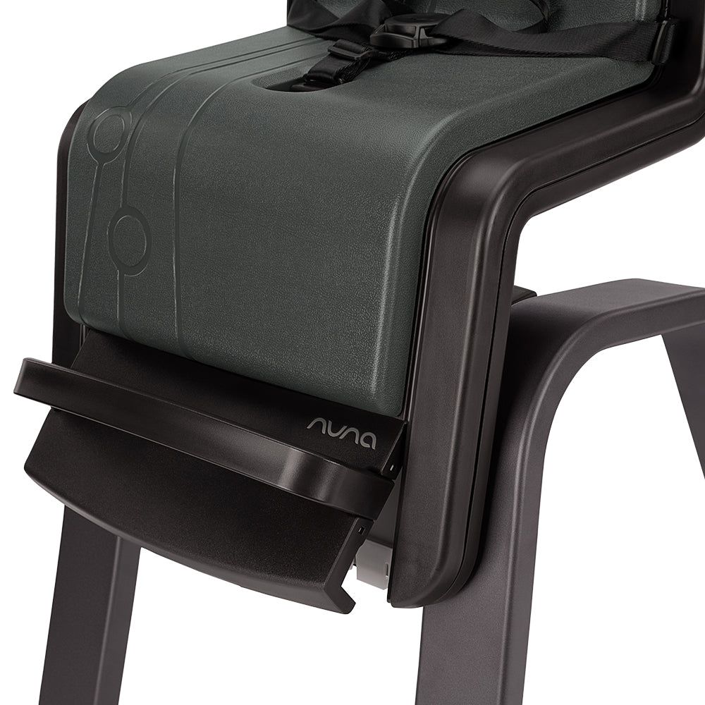 Foco na base do assento da cadeira Nuna ZAAZ, evidenciando a almofada de espuma e o logótipo Nuna no apoio para os pés.