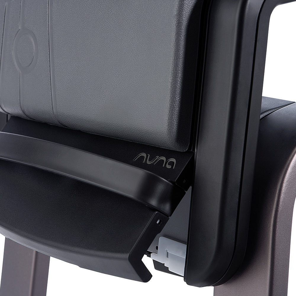 Detalhe do fecho de segurança e do logótipo Nuna na barra frontal da cadeira de refeição ZAAZ.