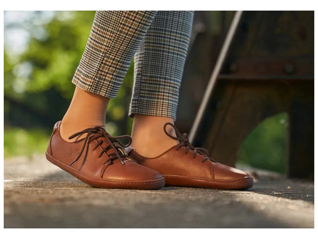 Pessoa a usar INCA castanho feminino, combinando os sapatos com roupa casual num ambiente ao ar livre.