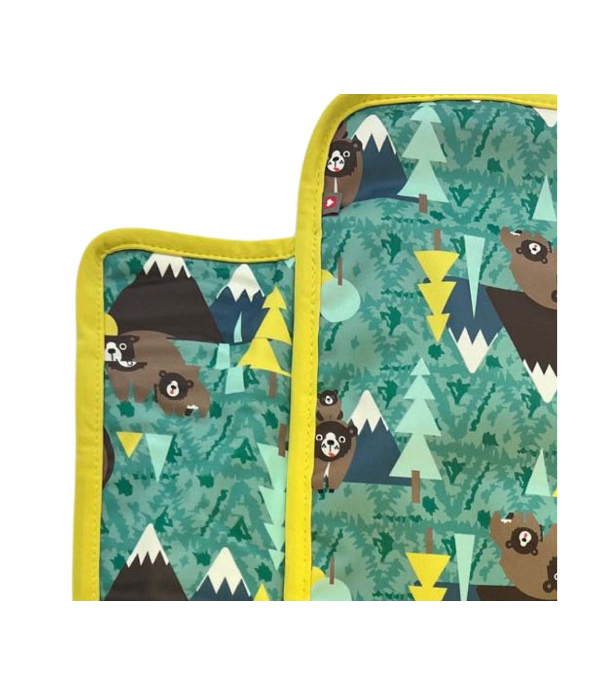 Detalhe aproximado do padrão de ursos e montanhas no muda fralda portátil Close Bear, com o rebordo amarelo.