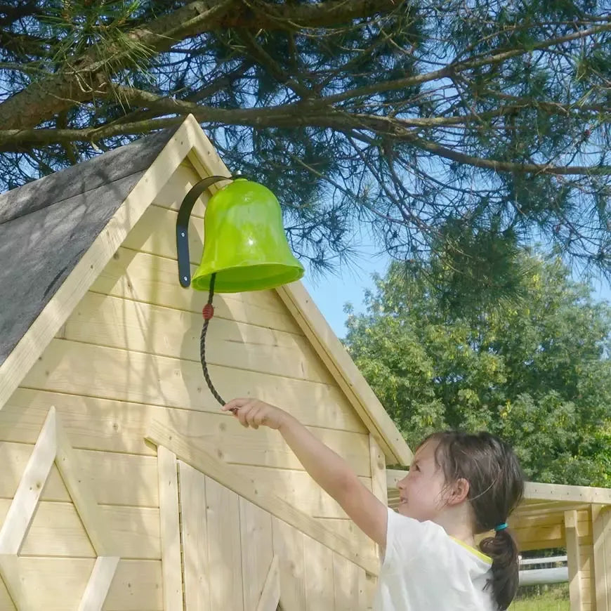 Campainha verde instalada numa casinha de madeira, parte do kit de acessórios Soulet para áreas de jogos exteriores.