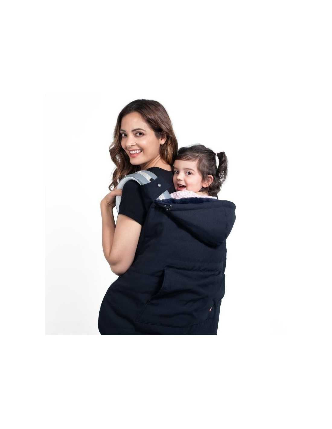 Mãe sorridente a usar a capa Wombat azul escura para transporte de bebé às costas, com a criança visível e feliz.