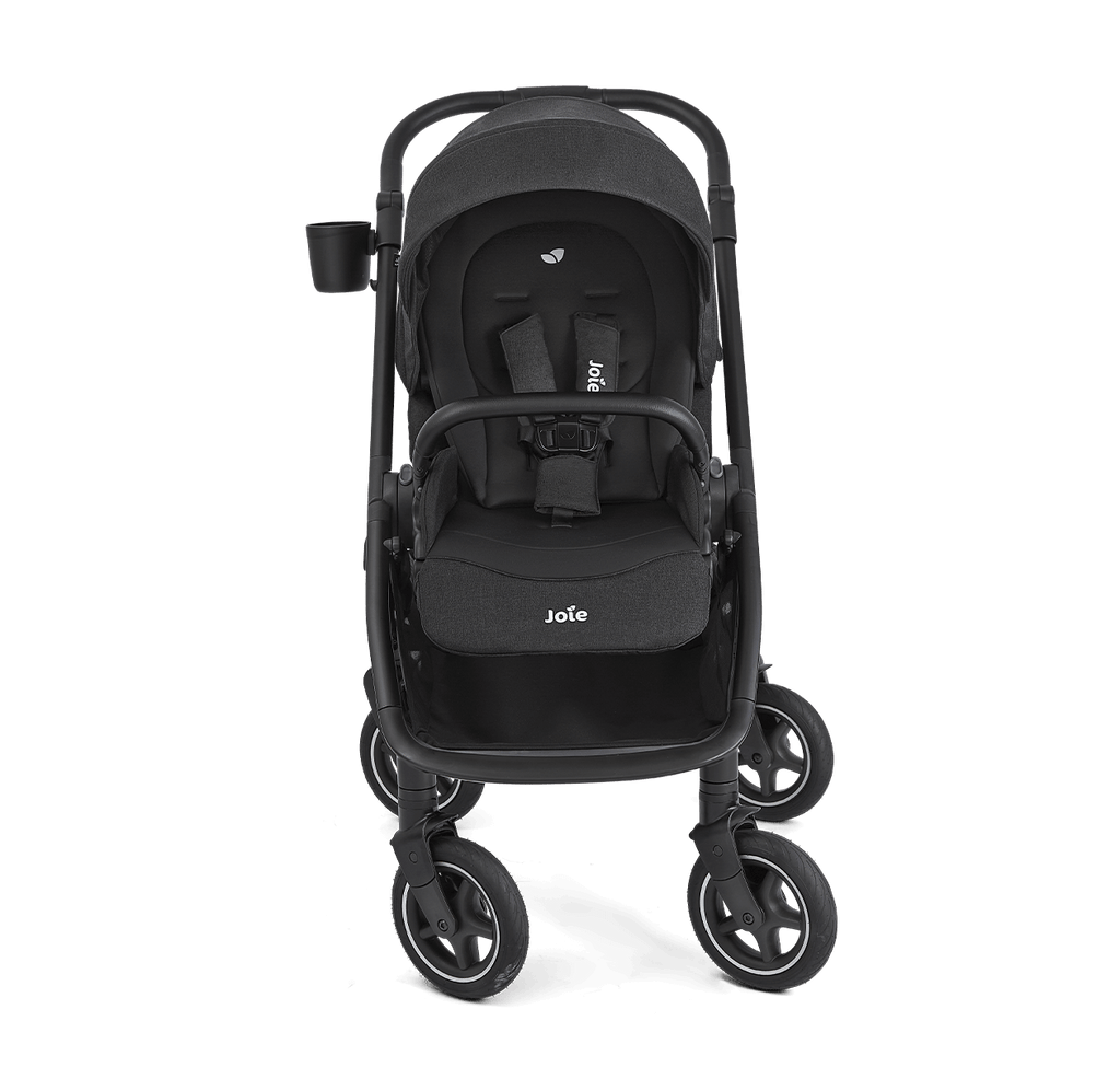 Vista lateral do carrinho Joie versadrift preto, destacando o assento reclinado e o cesto de arrumação em malha.