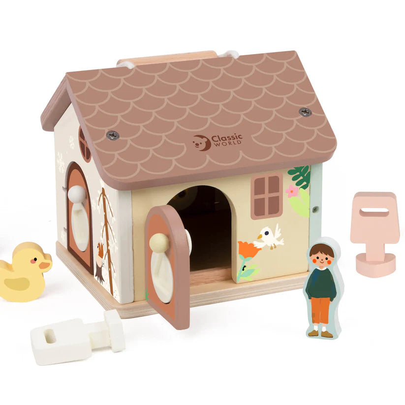 Perspetiva da Classic World Casa de Encaixes com uma porta aberta, revelando o interior, e as figuras de um menino, um pato e uma chave de madeira branca.
