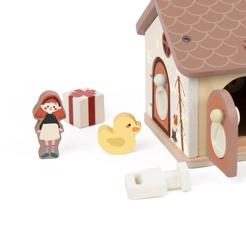Detalhe das figuras de madeira da Classic World Casa de Encaixes, incluindo uma menina, um presente vermelho e um pato amarelo, junto a uma chave e a uma parte da casa.