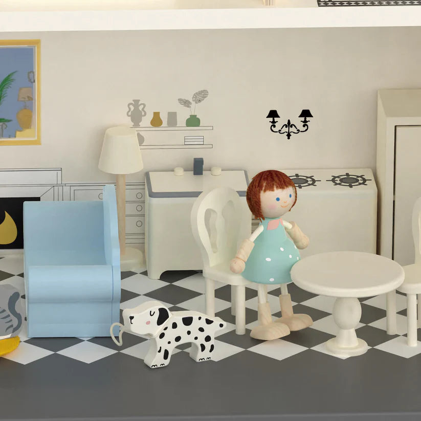 Pormenor da sala de estar e cozinha da casa de bonecas, com boneca, cão, sofá e mobiliário.