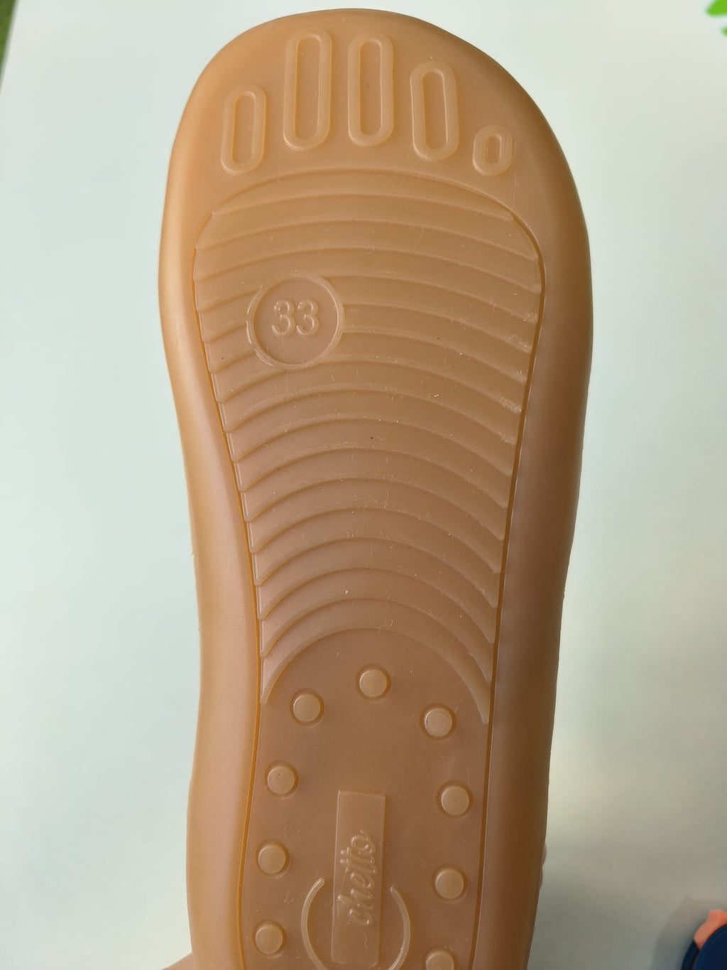 Sola flexível e fina da sapatilha Chetto, cor de borracha natural, com relevos de dedos, número de tamanho '33' e logótipo na base.