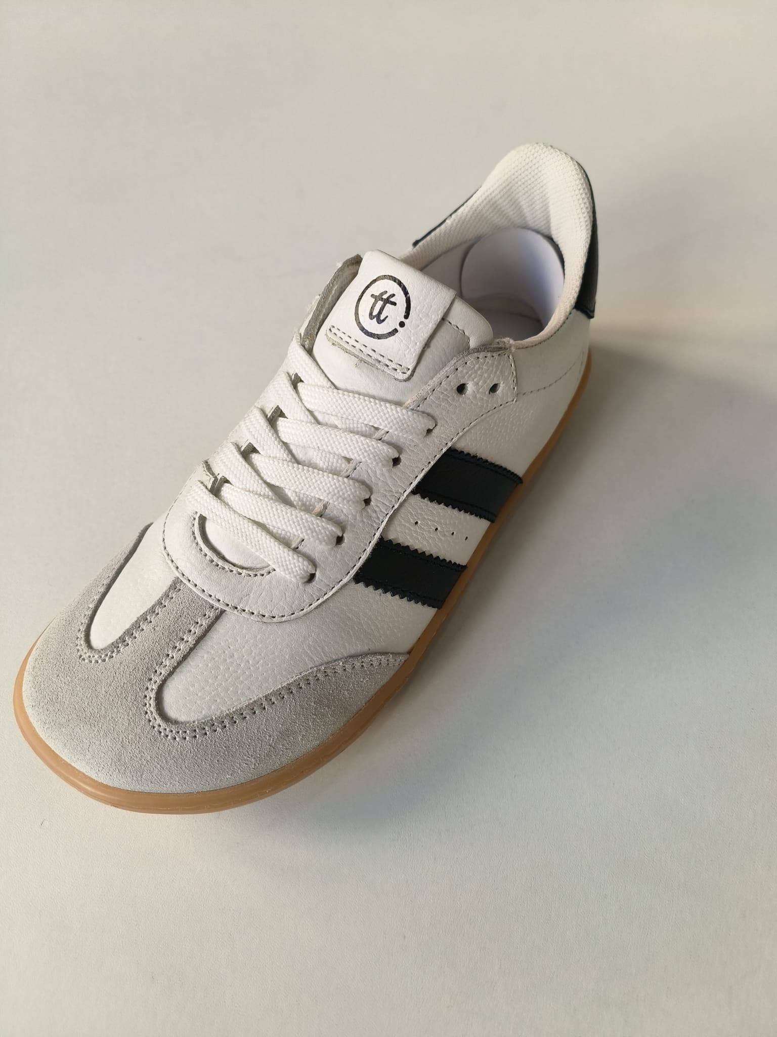 Sapatilha Chetto Barefoot branca em pele com riscas pretas laterais, ponteira em camurça cinza e fecho de atacadores brancos.