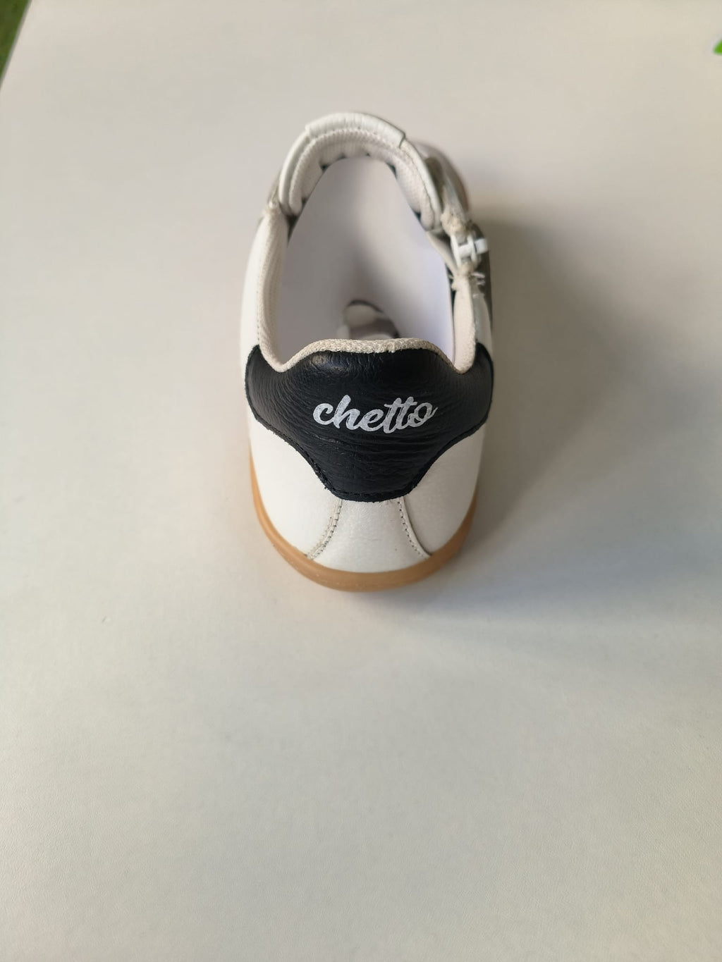 Vista traseira da sapatilha Chetto, evidenciando o reforço do calcanhar preto com a inscrição 'chetto' em branco.