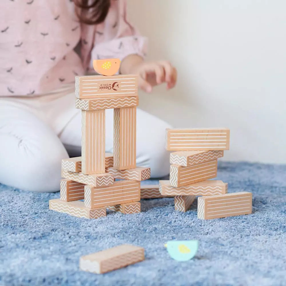 Criança a brincar com o Classic World Jogo de empilhar pássaros, construindo torres e desenvolvendo a imaginação.