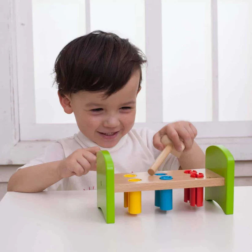 Criança sorrindo enquanto brinca com o Jogo de Martelar Classic World, um brinquedo educativo e divertido em madeira.