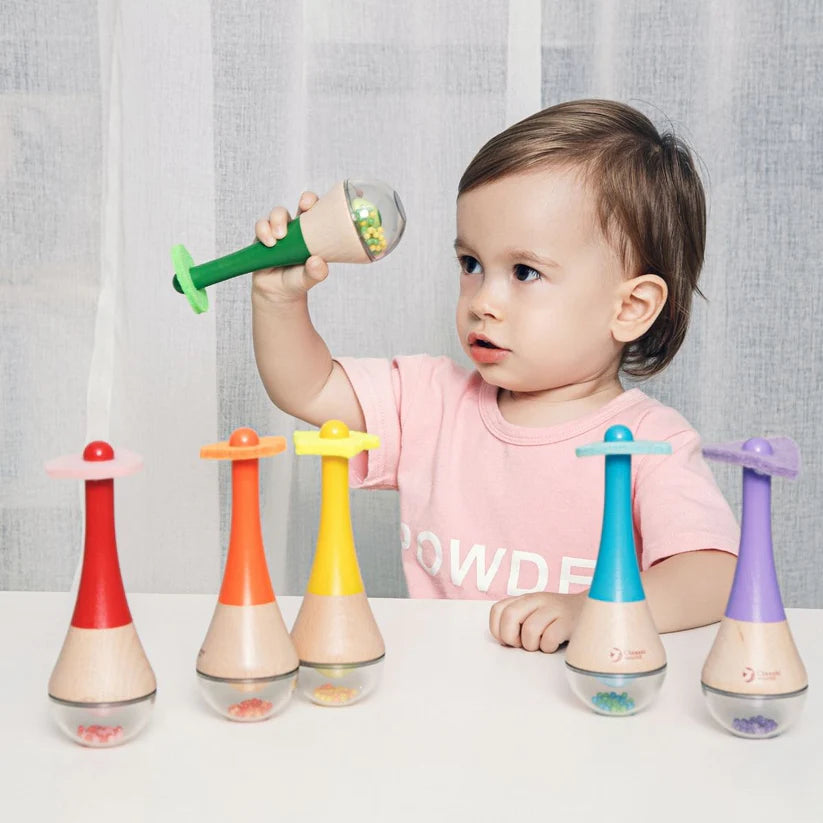 Bebé a brincar com as Classic World Maracas Arco Iris, mostrando as cores vibrantes e o design apelativo do brinquedo musical.