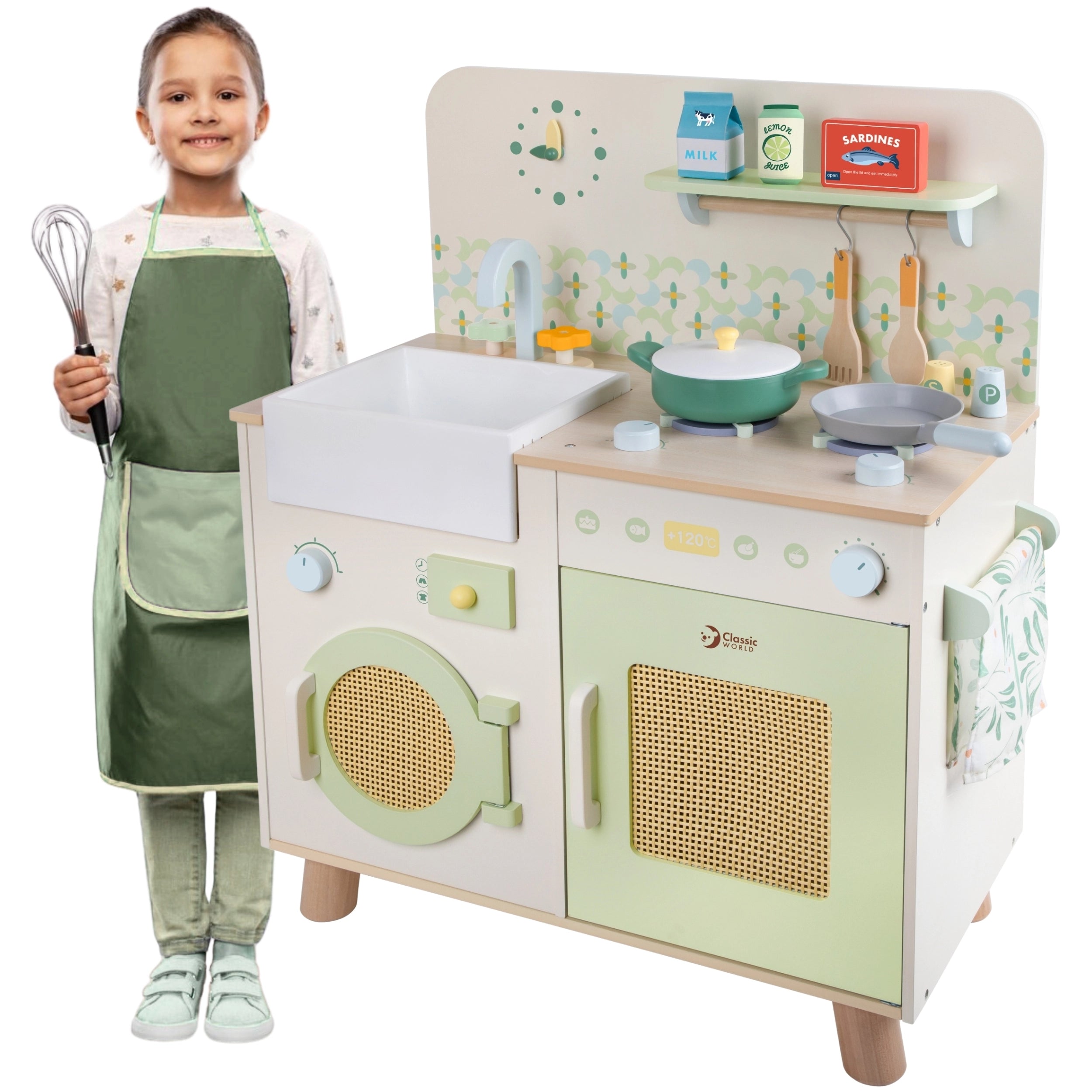 Criança sorridente com avental e colher, ao lado da cozinha de brincar Classic World Natural Kitchen.