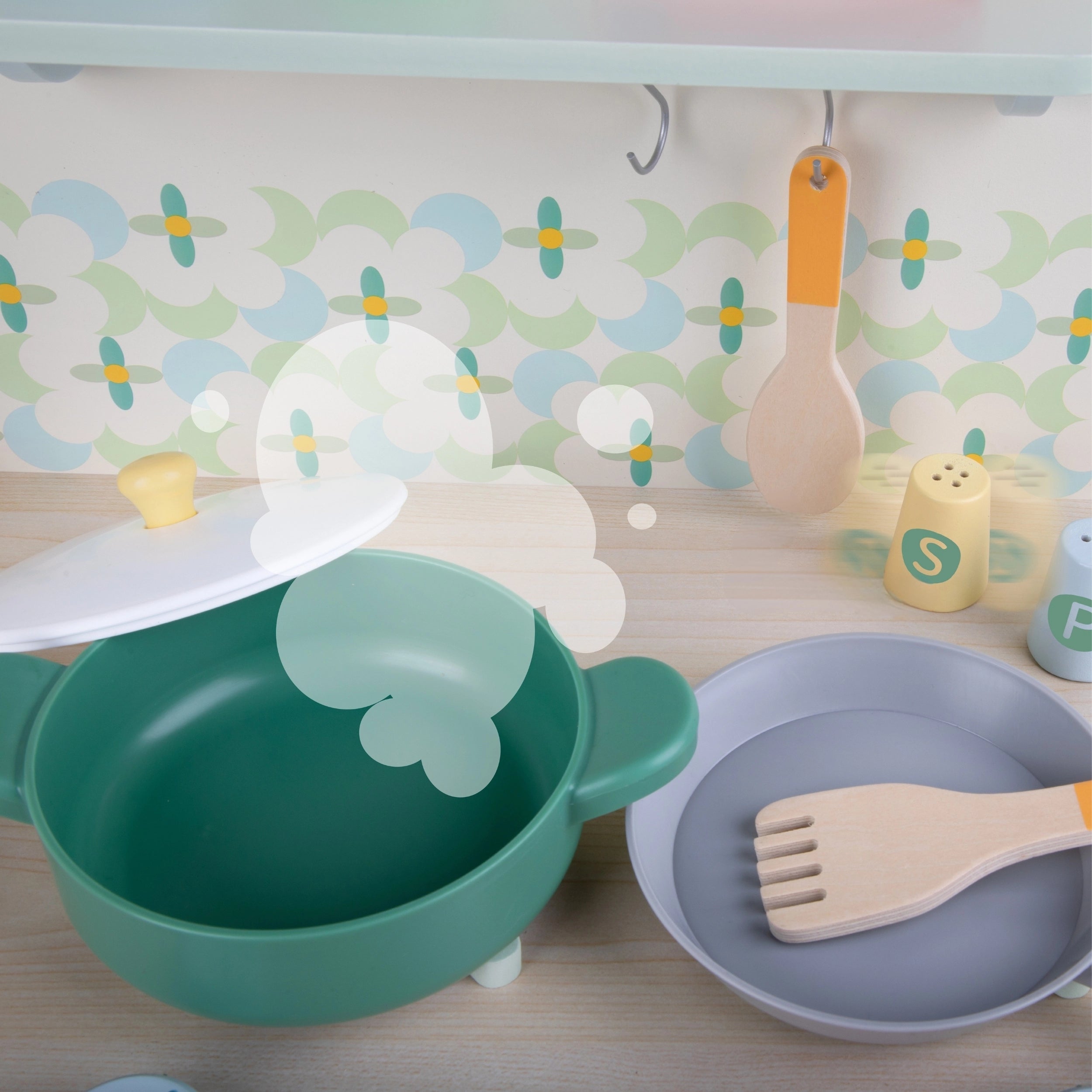 Menino feliz a brincar com a Classic World Natural Kitchen, uma cozinha de madeira multifuncional.