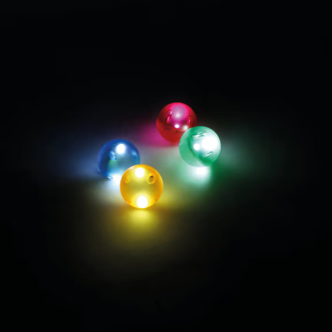 Quatro bolas luminosas coloridas (azul, rosa, verde, amarela) com luzes LED acesas, sobre um fundo escuro.