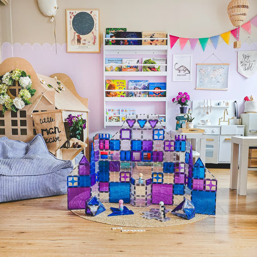 Castelo de blocos magnéticos Clever Clixx Mega Ice Crystal Pack num quarto infantil decorado, com outros brinquedos e livros ao fundo.
