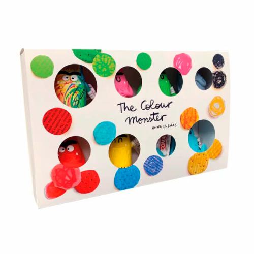 Embalagem do conjunto Comansi "O Monstro das Cores" com orifícios circulares a revelar as figuras de PVC lá dentro.