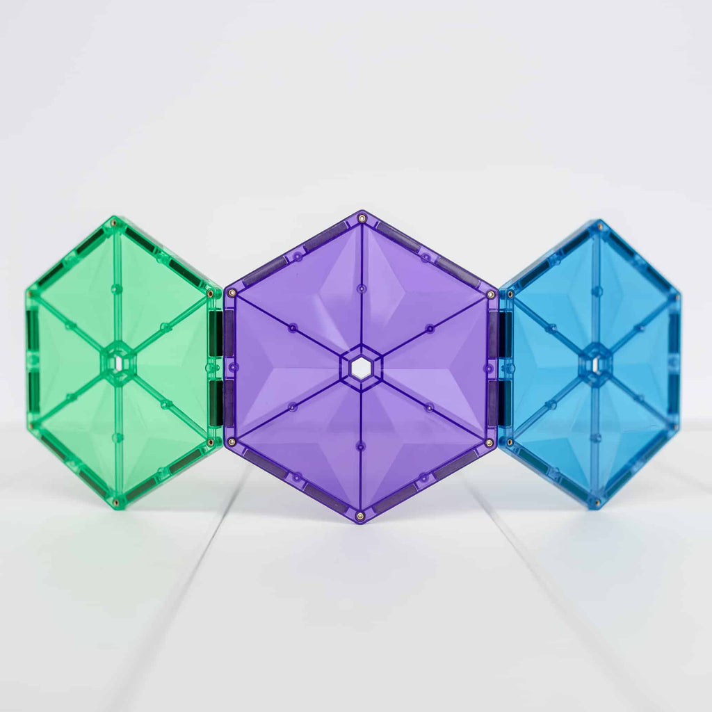 Três hexágonos grandes coloridos (verde, roxo, azul) de blocos magnéticos Connetix.