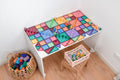Mesa com uma grande construção colorida feita com os blocos Connetix Pastel e outras peças de jogo.