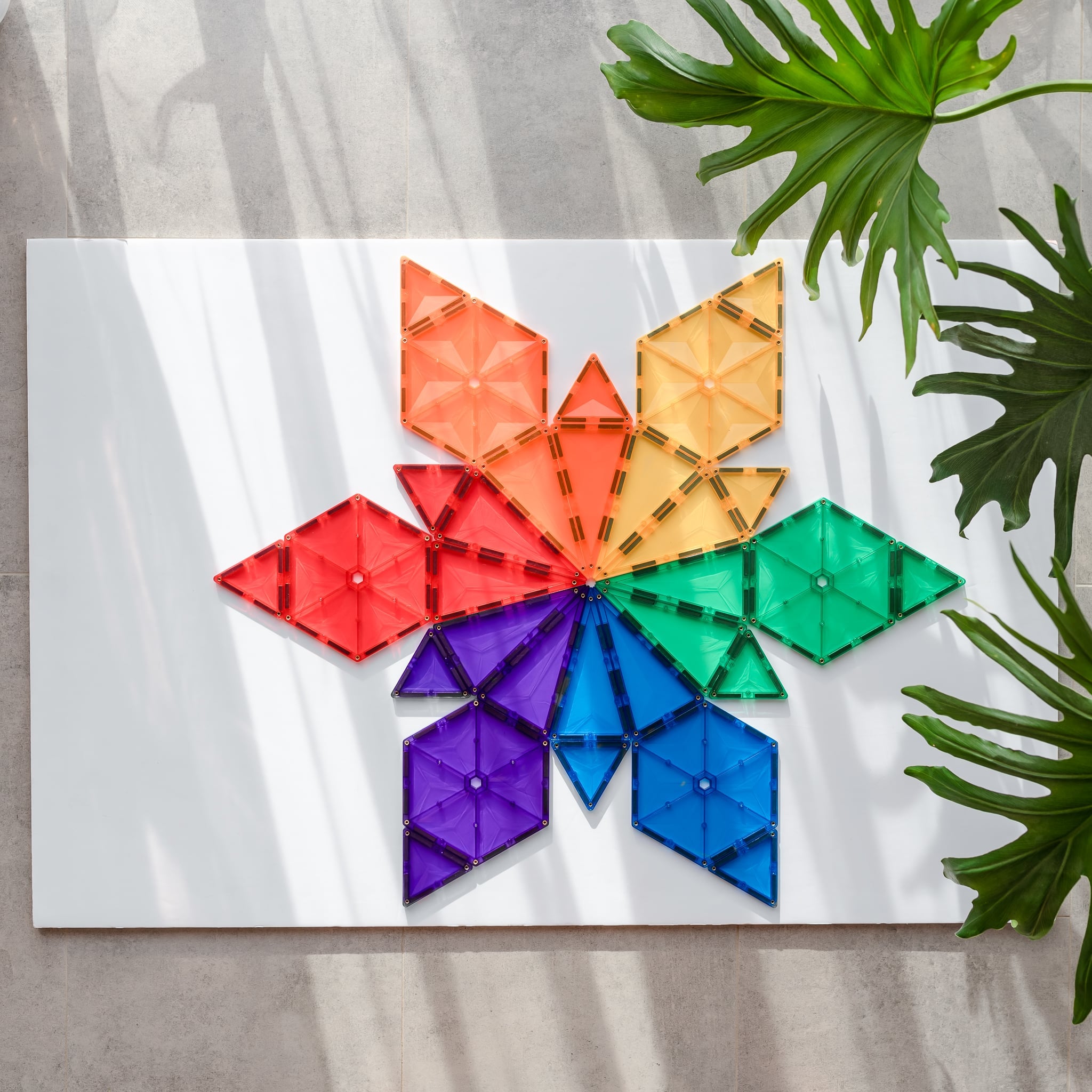 Construção colorida em forma de borboleta feita com blocos magnéticos Connetix do conjunto Rainbow Geometry.