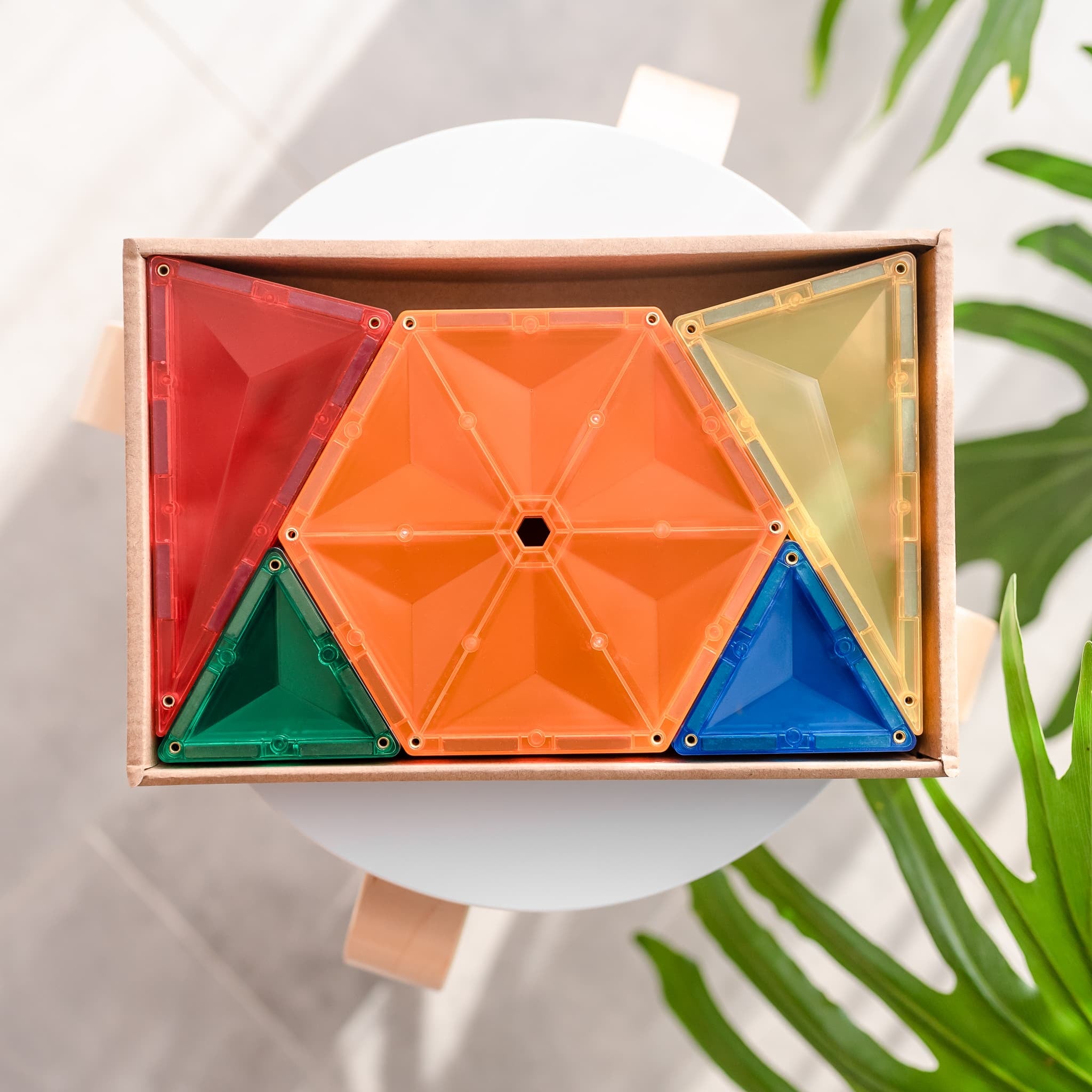 Vista de cima da caixa aberta do Connetix Jogo blocos Magnético Rainbow Geometry 30 peças, mostrando os hexágonos e triângulos.
