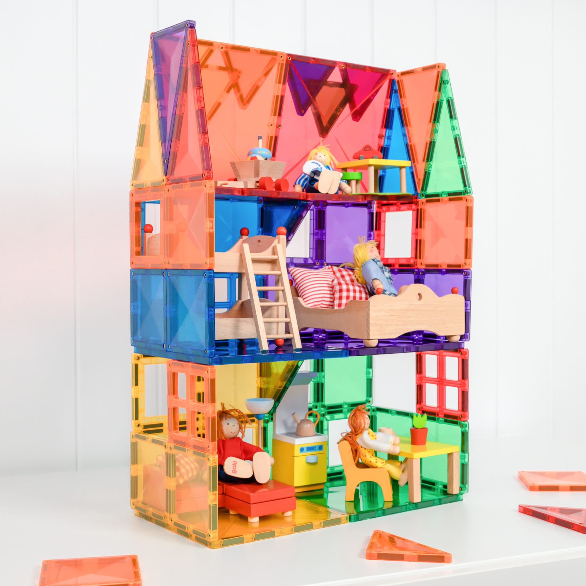 Casa de bonecas de vários andares construída com peças Connetix Rainbow Starter 60 pc e bonecos.