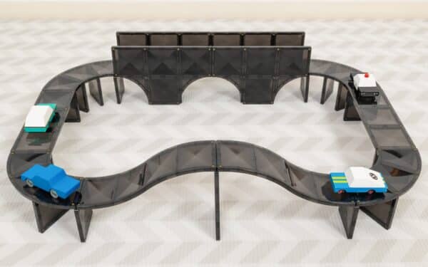 Pista de estrada magnética Connetix preta completa, em forma oval, com ponte e vários carros de brincar em cima.