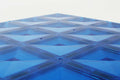 Close-up da placa base magnética Connetix azul, mostrando detalhes da construção. Jogo educativo.