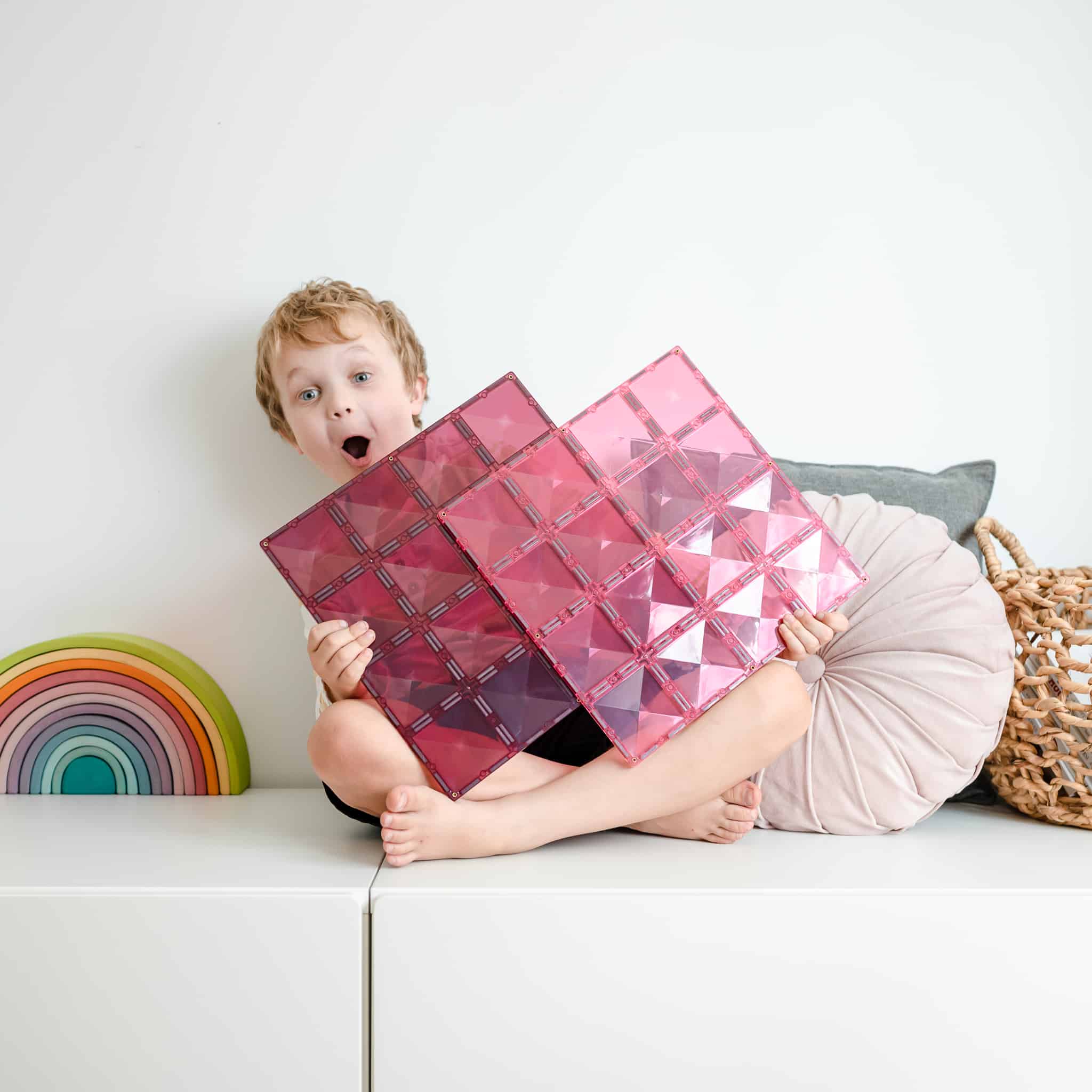 Criança a brincar com as bases magnéticas Connetix Pink & Berry. Brincadeira criativa e desenvolvimento infantil.