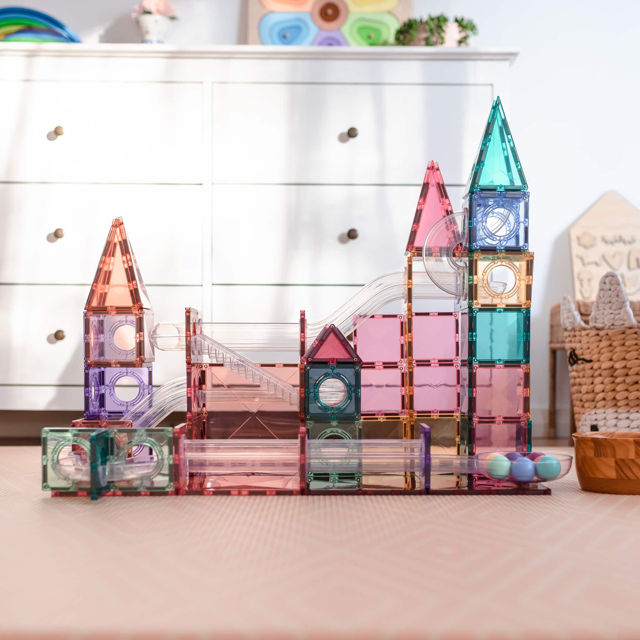 Exemplo de construção tipo castelo com o Connetix Jogo blocos Magnético Ball Run Pastel 106 pc no chão.