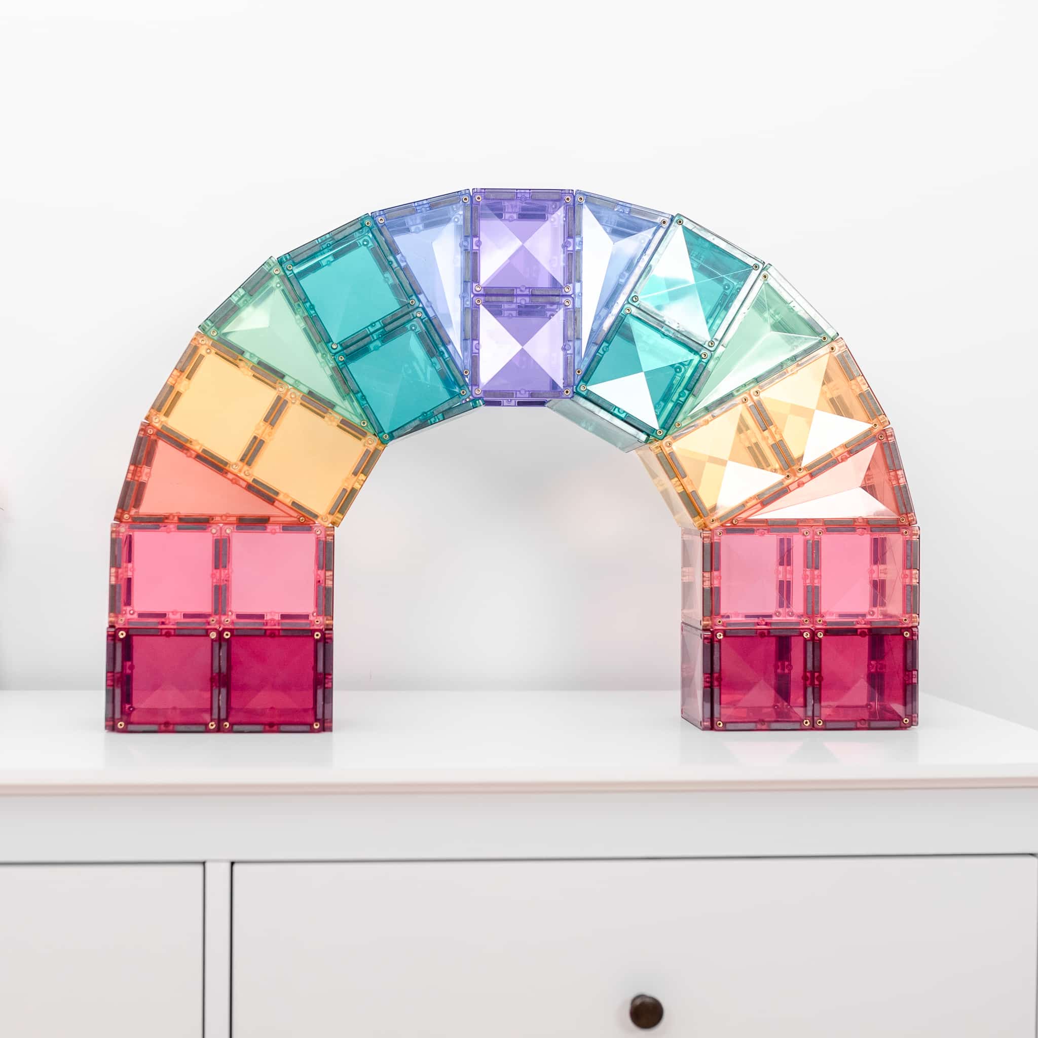 Estrutura de arco-íris construída com blocos magnéticos Connetix pastel de 120 peças.