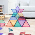Construção de estrela com blocos magnéticos Connetix Pastel Shape Expansion Pack no chão.