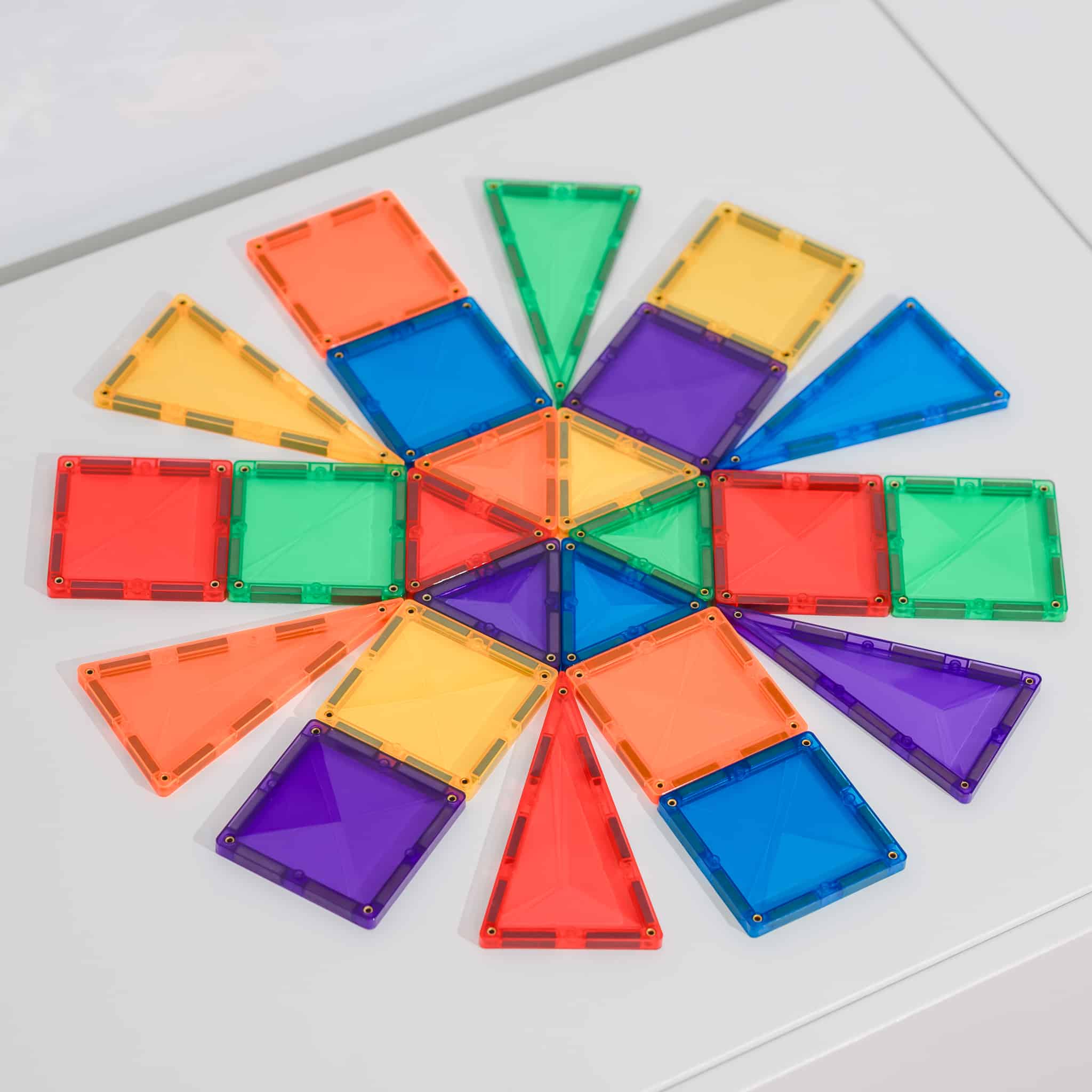 Connetix Jogo blocos Magnético Rainbow Mini 24 pc, as 24 peças coloridas (quadrados e triângulos) dispostas num padrão.