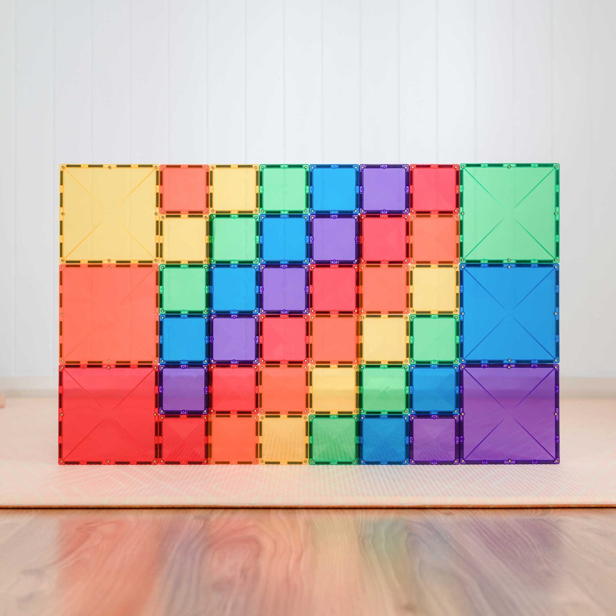 Parede ou painel plano construído com blocos magnéticos quadrados Connetix Rainbow Square em grid.