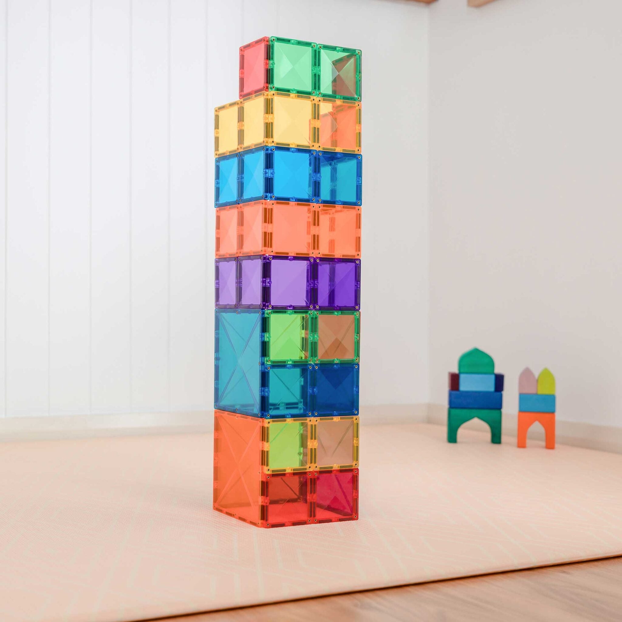 Construção complexa de torre com blocos magnéticos Connetix Rainbow Square coloridos.
